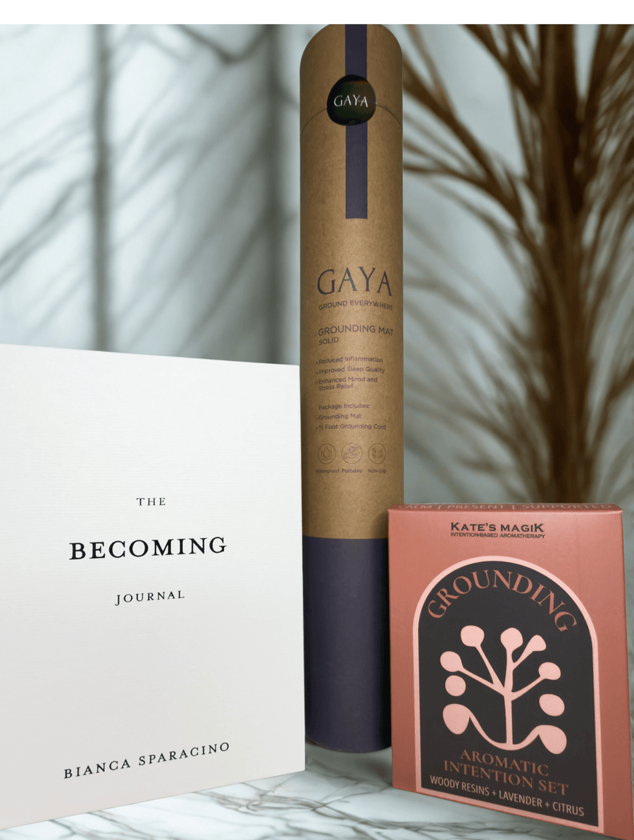 The Becoming' journal, GAYA grounding  mat, and Grounding aromatherapy spray bottles styled on marble, Grounding gift set
